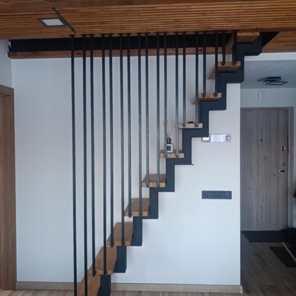 Laiptasija su kampuotu dugnu ir kvadratinio vamzdelio turėklais nuo pakopų iki lubų